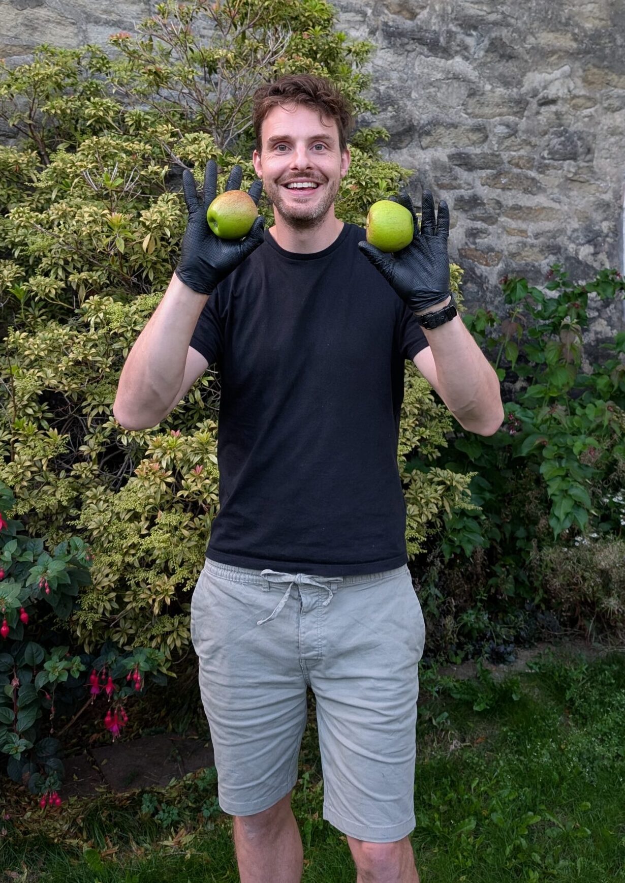 Matthew holding a green apple in each hand recently harvested