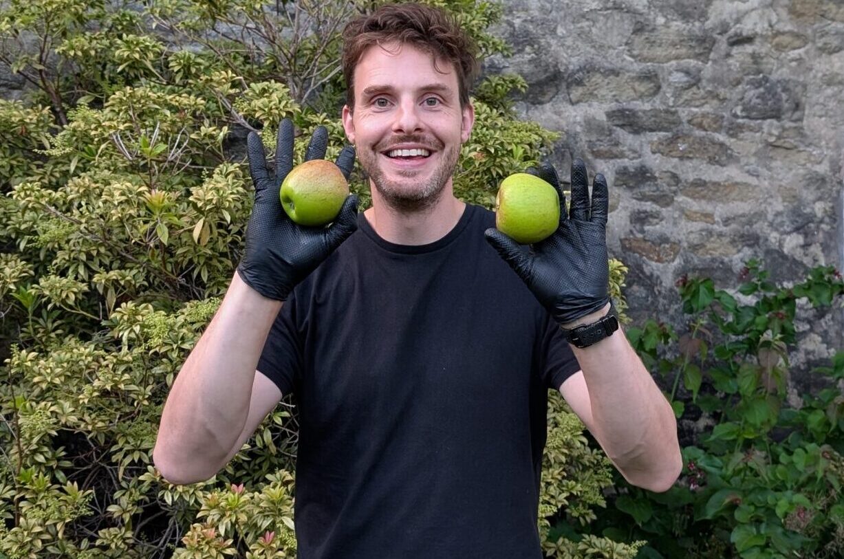 Matthew holding a green apple in each hand recently harvested